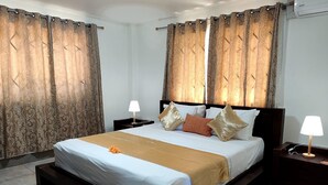 Habitación de hotel con una cama grande, dos mesitas de noche y una flor decorativa en la cama.