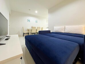 Una habitación de hotel con cama, escritorio, silla y televisor.