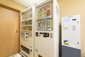 Vending machines with a variety of beverages and snacks, a door, and a utility meter. - R B Hotel Kyoto Eki Hachijoguchi (Kyoto)