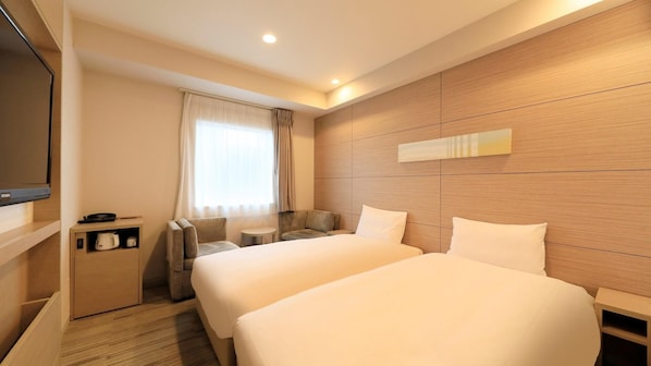 A hotel room with two beds, a TV, a coffee maker, and a window with curtains. - Viainn Higashi Ginza (Tokyo)