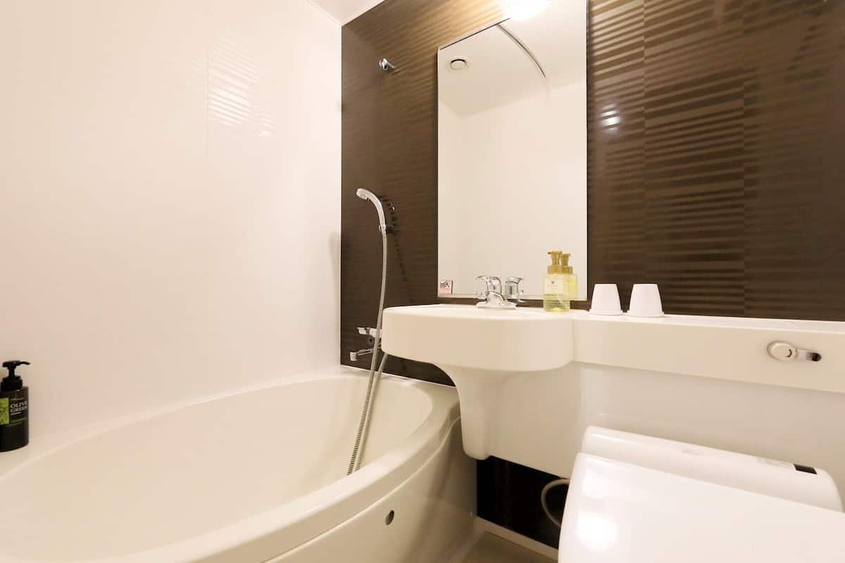 Ein modernes Badezimmer mit einer freistehenden Badewanne, einem Waschbecken und einem Spiegel.