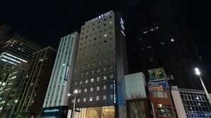 A hotel with a modern facade, multiple floors, and illuminated signage. - Viainn Higashi Ginza (Tokyo)