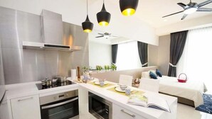 A modern kitchen with a central island, built-in oven, and stainless steel appliances. - A Place Define Happiness in M Suite Klcc (Kuala Lumpur)
