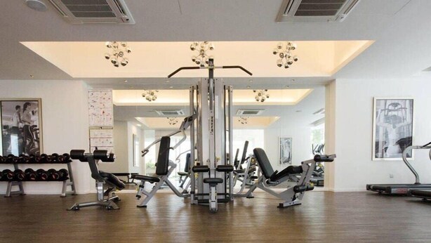 A gym with various exercise equipment, including dumbbells, benches, and a weight machine. - A Place Define Happiness in M Suite Klcc (Kuala Lumpur)