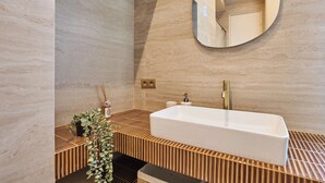 A modern bathroom with a freestanding bathtub, wooden slatted vanity, and a large mirror. - Charming Apartment in the Center of Paris (Paris)