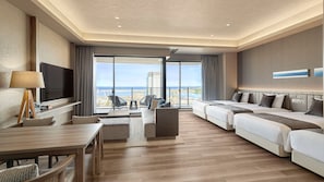 A hotel room with a balcony, a TV, a desk, and two beds.