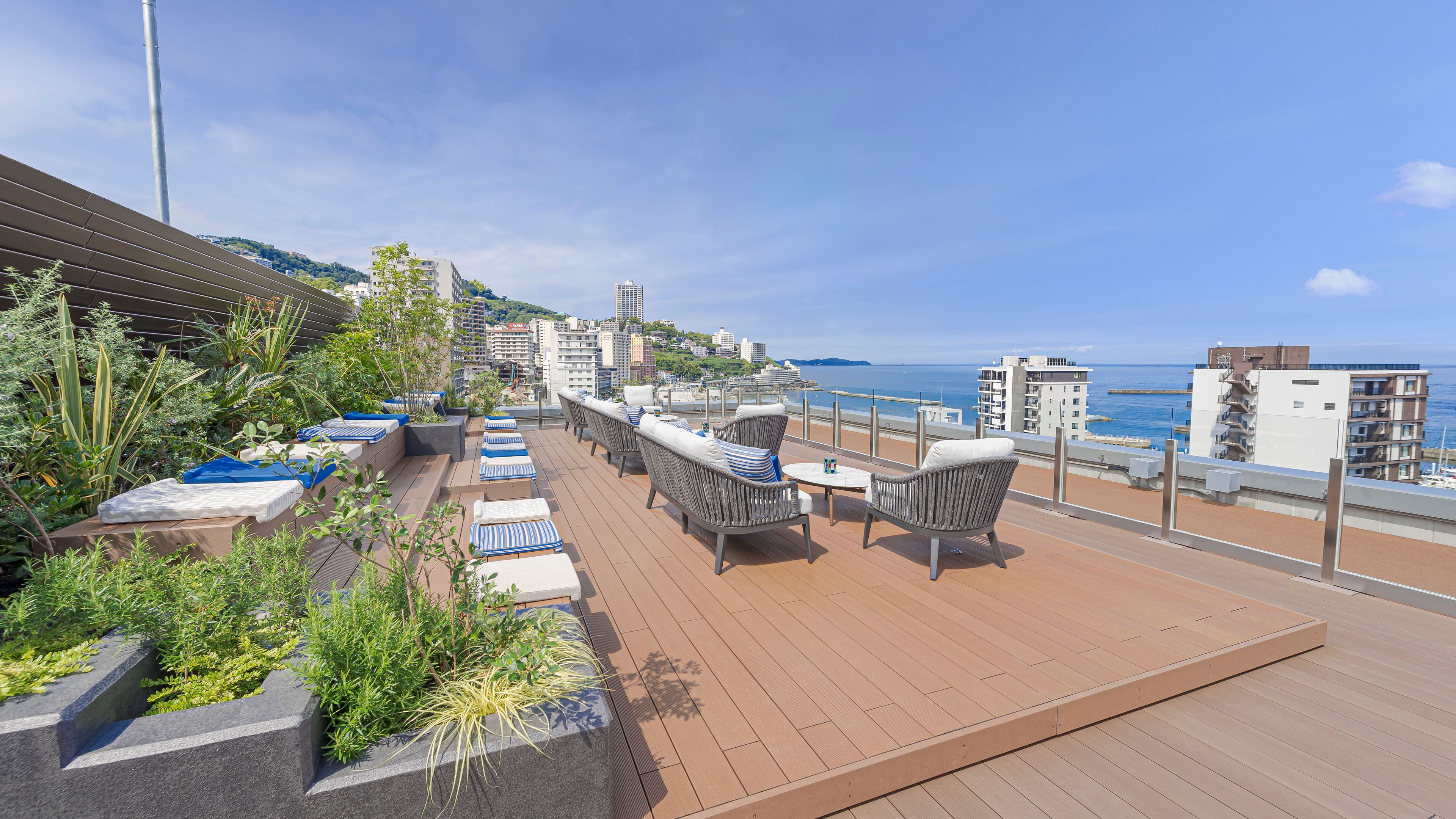 A rooftop terrace with seating and a view of the sea.