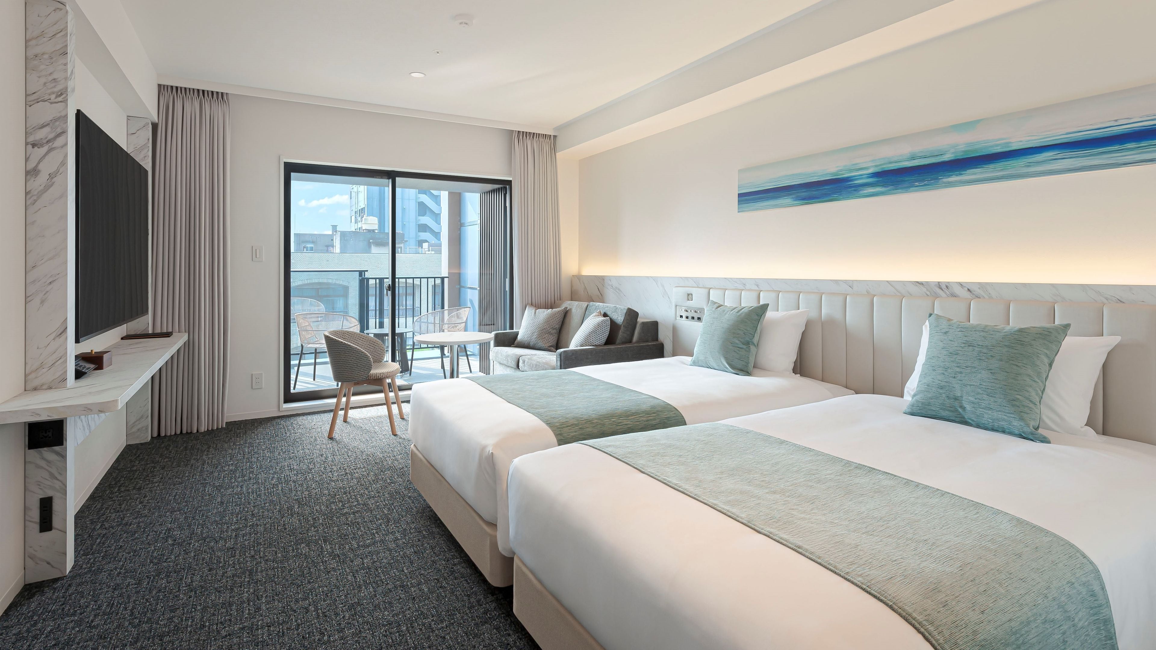 A hotel room with two beds, a TV, a balcony, and a painting on the wall.