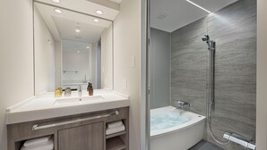 A modern bathroom with a large mirror, a vanity with a sink, and a separate shower area. - Village Atami (Atami)