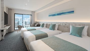 A hotel room with two beds, a desk, a chair, and a balcony with a view.