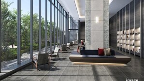 A modern lobby with large windows, a seating area with sofas and chairs, and a wall with shelves. - Village Atami (Atami)