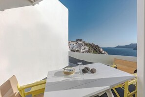 Una mesa blanca con vista a un pueblo costero y al mar.