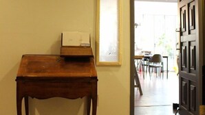 A hallway with a wooden table, a door, and a window with blinds. - Jinwoo Residence (Geoje)