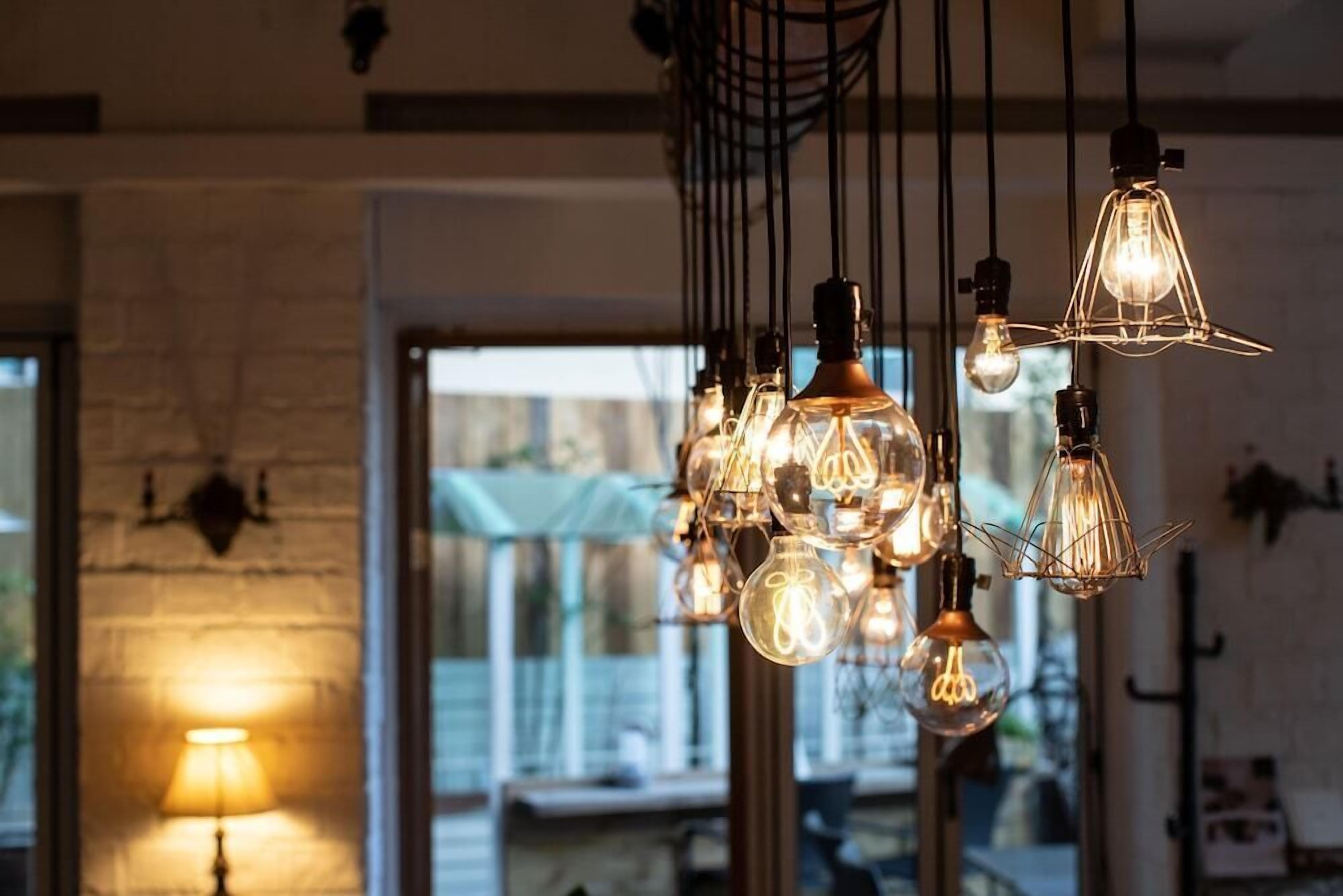A room with hanging light fixtures and a visible door leading outside.