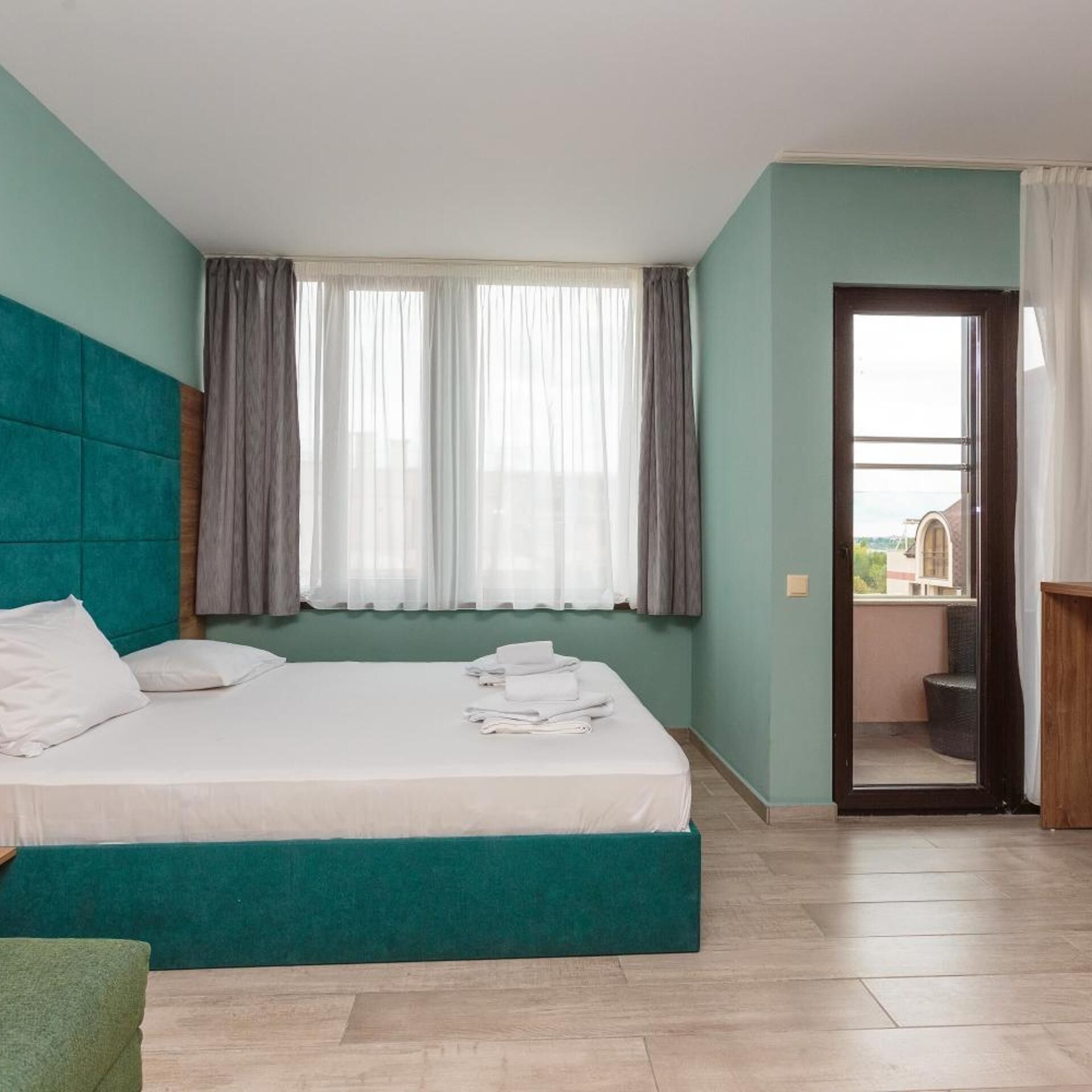 Une chambre d’hôtel avec un lit, une vue sur l’extérieur et un balcon.