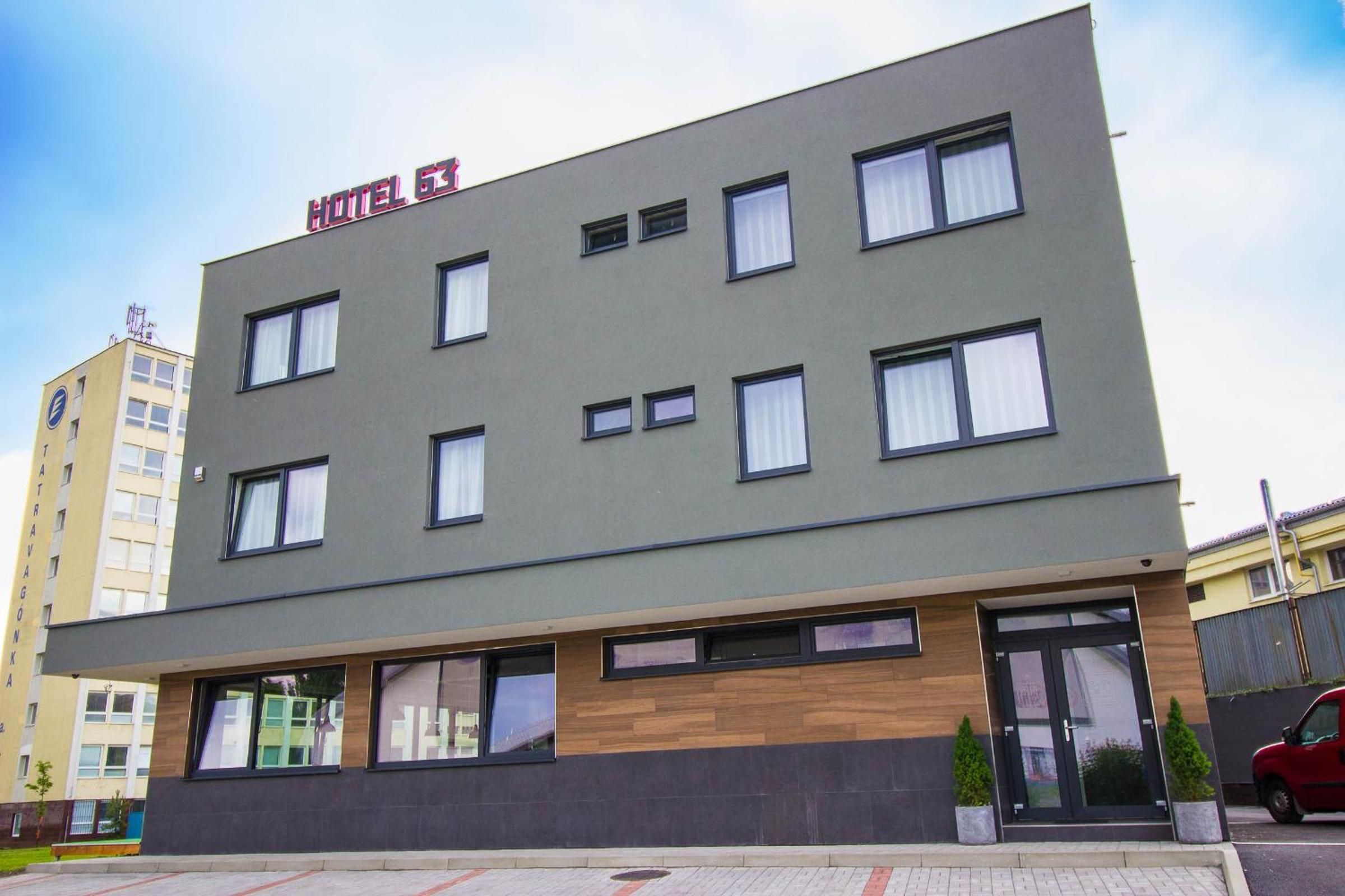 Un edificio moderno de hotel con fachada plana, múltiples ventanas y un letrero que indica que es un hotel.