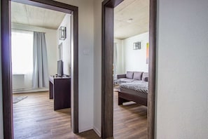 Una habitación con una cama, un escritorio con computadora y un espejo.