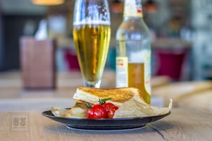 Un plato con un sándwich y tomates cherry sobre una mesa.