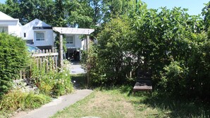 Área residencial com um caminho que leva a uma casa com varanda.