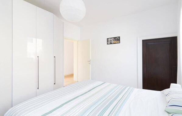 A bedroom with a bed, a wardrobe, a door, and a light fixture. - Bella Vita Charming House (Venice)