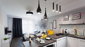 Una cocina moderna con comedor, sofá y cama al fondo.