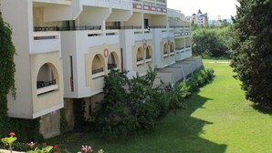 A multi-story hotel with balconies, a garden area, and a clear sky. - Duni Royal Resort - Hotel Pelican (Sozopol)