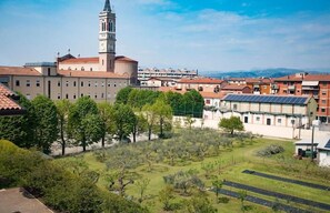 A historic building with a prominent tower, surrounded by residential buildings and a well-maintained garden. - STH Verona (Verona)