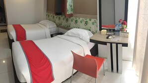 A hotel room with two beds, a desk, and a chair. - Prince Boulevard Hotel (Manado)