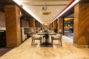 Un comedor espacioso con una mesa larga, múltiples sillas y un diseño de techo moderno.