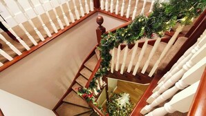 Eine Treppe mit weißer Geländer, verziert mit Grünpflanzen und roten Verzierungen.