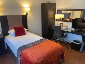 A hotel room with a bed, a desk, a chair, a television, and a mirror. - Staverton Park Hotel and Golf Club (Daventry)