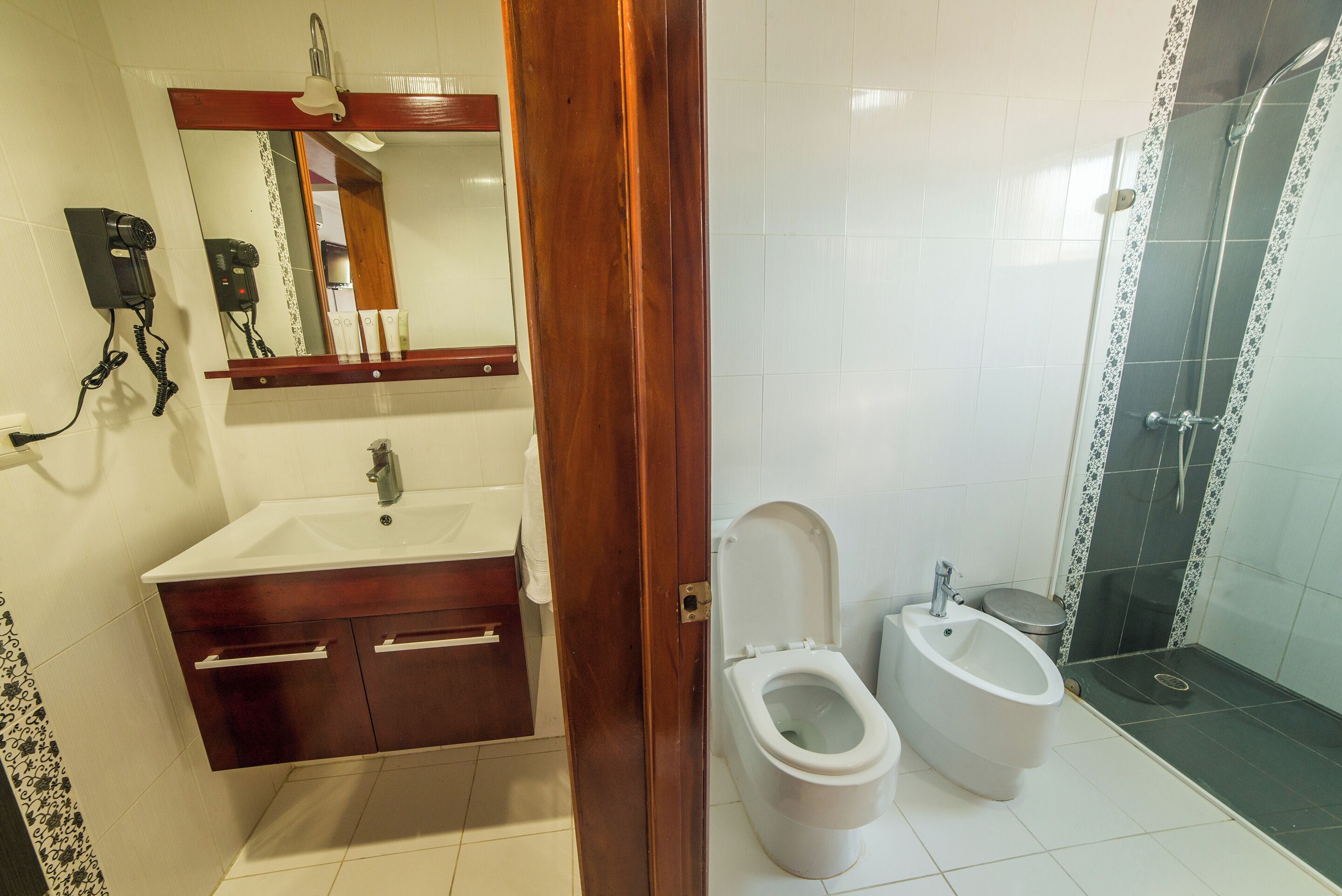 Ein Badezimmer mit Waschbecken, Ablagefläche, Spiegel und Bidet.