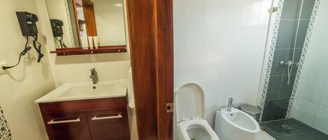 Ein Badezimmer mit Waschbecken, Ablagefläche, Spiegel und Bidet.
