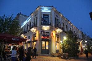 A building with a prominent 'Goodys' sign, multiple balconies, and a flag. - Hotel Panellinion (Trikala)