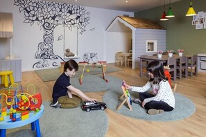 A room with a play area, a dining table, and a wall mural. - Manor West (Tralee)
