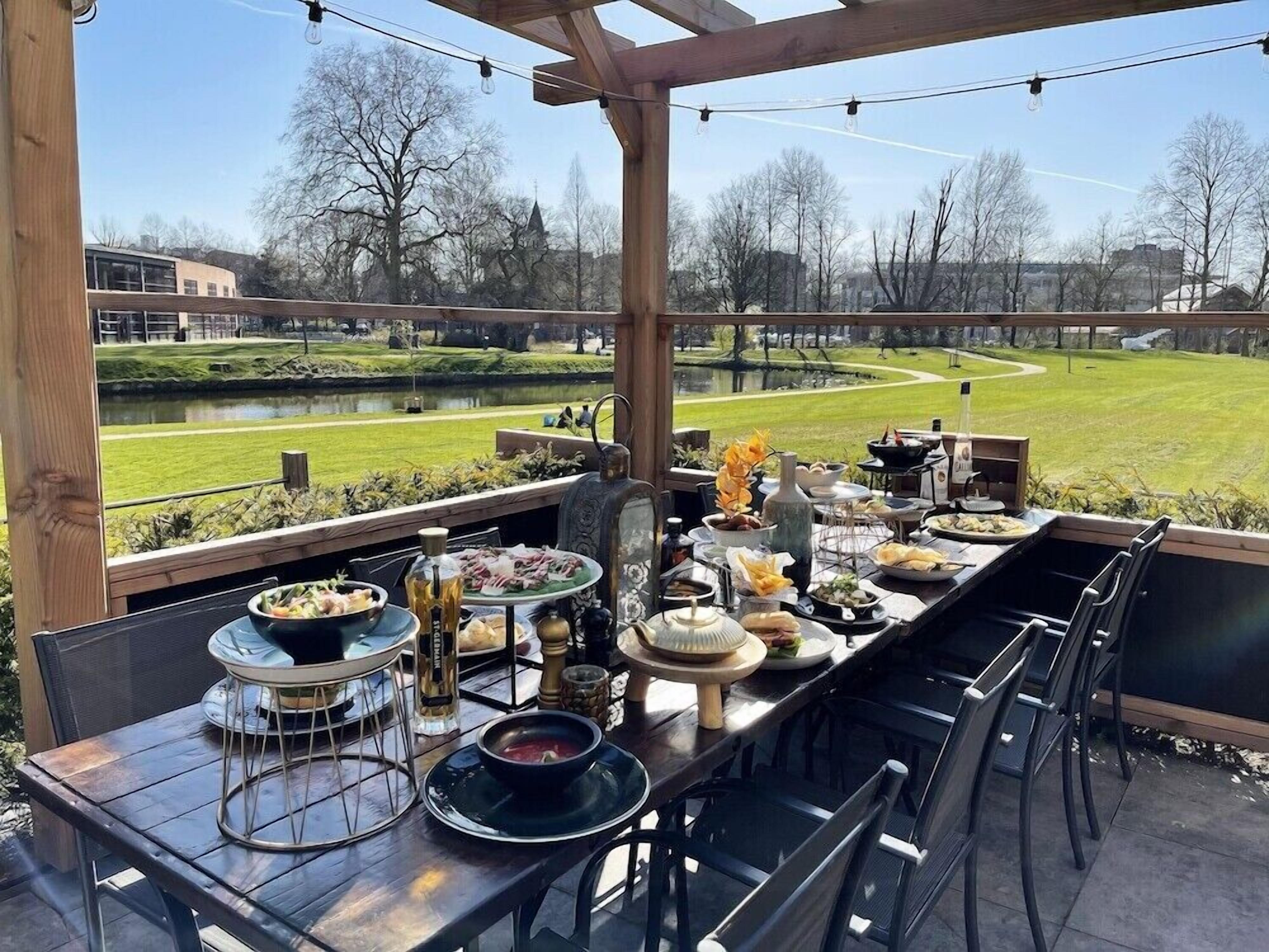 An outdoor dining area with a view of a park and buildings.