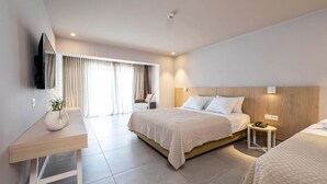 Ein modernes Hotelzimmer mit einem großen Bett, Nachttischen, einem Schreibtisch und einem an der Wand befestigten Fernseher.