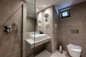 Une salle de bain moderne avec une douche à parois de verre, un lavabo blanc, un miroir et des toilettes.