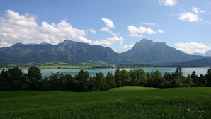 Paisagem montanhosa com um lago e um farol.