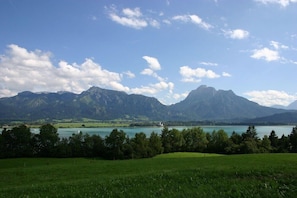 A mountainous landscape with a lake and a lighthouse. - Mueller (Schwangau)