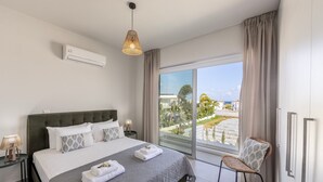 Una moderna camera d'albergo con un letto grande, vista all'esterno e un balcone.