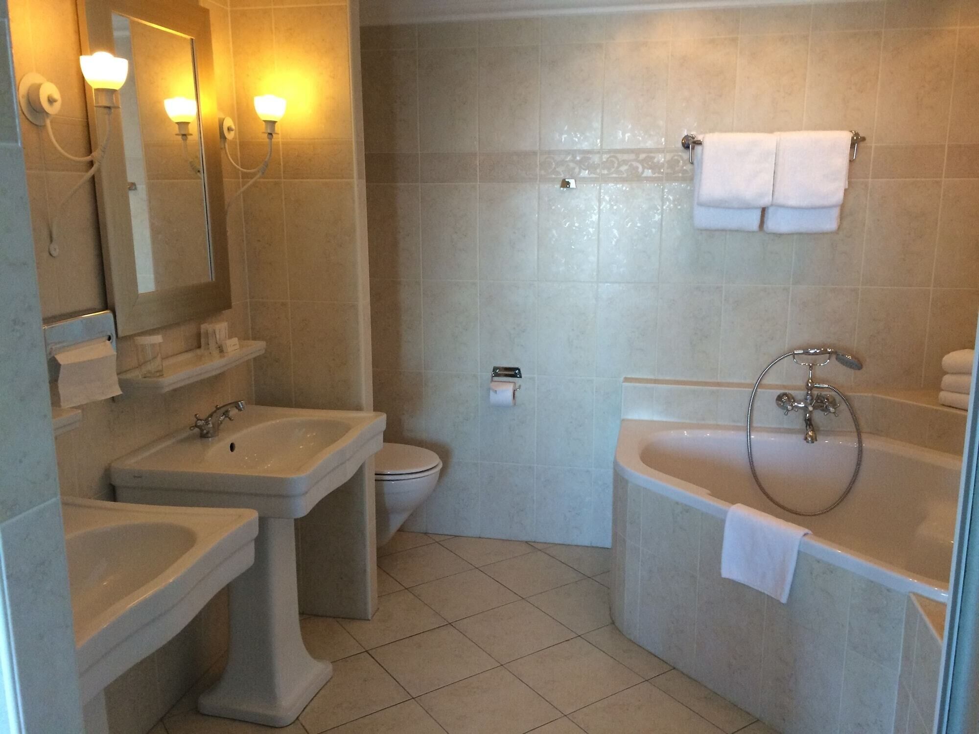 Een badkamer met een wastafel, toilet en bad.