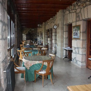 A rustic dining area with stone walls, wooden tables, and chairs. - Hotel Balneario De Corconte (Valle De Valdebezana)