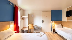 Habitación de hotel con dos camas, un escritorio, una silla, un televisor y una puerta con un cartel.
