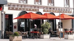 Een hotel met terras en een bord waarop staat 