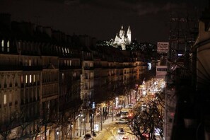 A nighttime cityscape with historic buildings and a prominent cathedral in the background. - Hotel de L'exposition Republique (Paris)