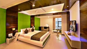 Une chambre d’hôtel moderne dotée d’un grand lit, d’un bureau, d’une télévision et offrant une vue sur la mer.