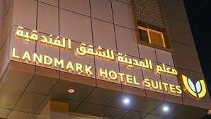 A hotel sign with Arabic and English text, indicating it is the Landmark Hotel Suites. - Landmark Hotel Suites (Tabuk)