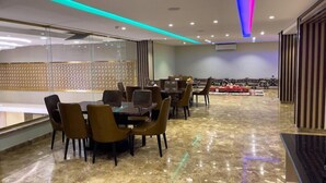 A modern dining area with marble flooring, leather chairs, and tables. - Landmark Hotel Suites (Tabuk)