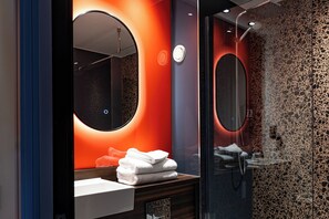 A modern bathroom with a round mirror, a sink, and a glass shower enclosure. - Village Birmingham Walsall - Hotel & Leisure Club (Walsall)